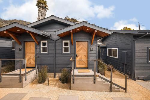 斯廷森海滩Mini Shortboard Room with a Queen Bed的院子里设有木门的黑色房子