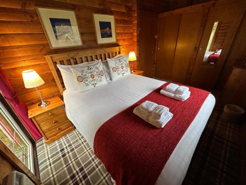 达农Pucks Glen Lodges, Rashfield, by Dunoon的一间卧室配有一张大床和毛巾