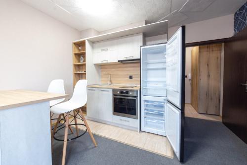 瓦尔纳Luxury Studio Apartment - Varna Residens的厨房配有冰箱和桌椅