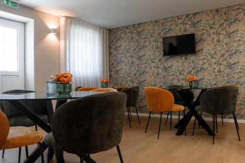 布拉加Quinta das Areias - Solar da Pena的一间带2张桌子和椅子的用餐室以及电视