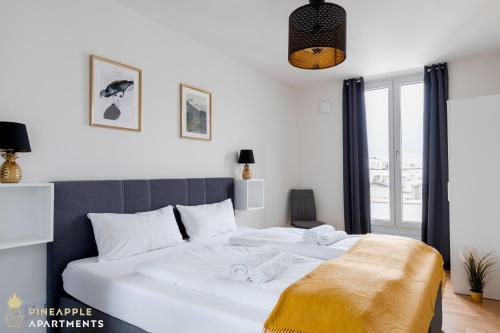 德累斯顿Pineapple Apartments Dresden Altstadt V - 112 qm - 1x free parking的卧室配有带毛巾的大型白色床
