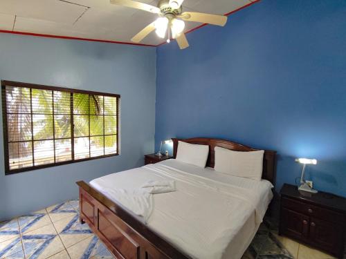 大玉米岛卡萨加拿大酒店的蓝色卧室配有一张带吊扇的床