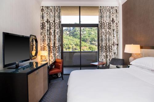 圣地亚哥Sheraton Mission Valley San Diego Hotel的酒店客房设有一张床和一个大窗户