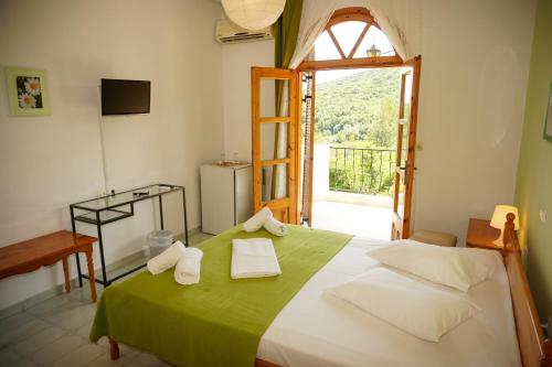 帕拉利亚潘塔利莫诺斯Irida Rooms 'n' Pool - Cozy Summer Escape的卧室配有一张带窗户的绿色白色床。