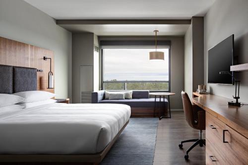 兀兰Houston CityPlace Marriott at Springwoods Village的一间卧室配有一张床、一张桌子和一张沙发