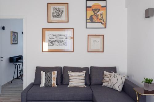 罗马Olimpico Apartment - Zen Real Estate的客厅配有灰色的沙发和墙上的照片