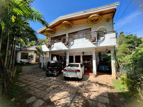 康提Kandy IVY Banks Holiday Resort的停在房子前面的白色汽车