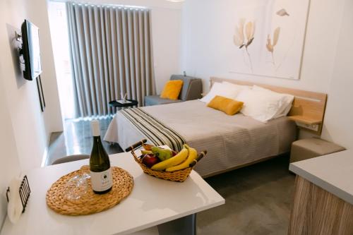 纳弗帕克托斯MAGNOLIA SUITES的一间房间,配有一张床和一张桌子上的一篮水果