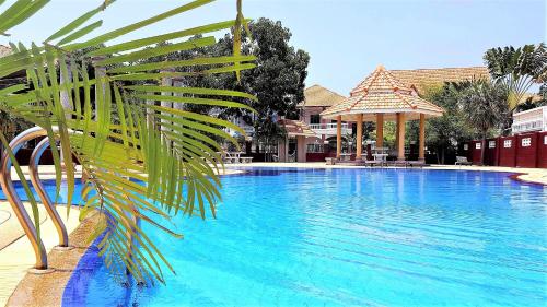 南芭堤雅POTTERLAND Luxury Pool Villa Pattaya Walking Street 6 Bedrooms的前方的蓝色游泳池,棕榈树