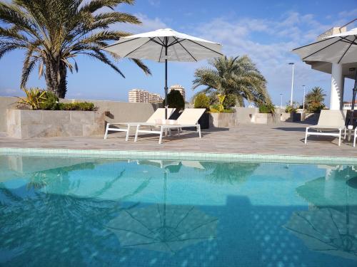 拉曼加戴尔马尔梅纳Boutique Hotel Colina del Emperador的一个带两把椅子和遮阳伞的游泳池