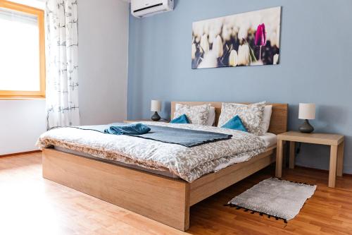 包道乔尼托毛伊Tulipános Ház的一间卧室配有一张蓝色墙壁的床