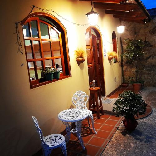 El CarmenEl Molino Hostal的庭院设有两把椅子、一张桌子和一扇窗户。