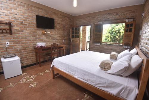蒂安瓜Sítio do Bosco Park的一间卧室设有一张床和砖墙