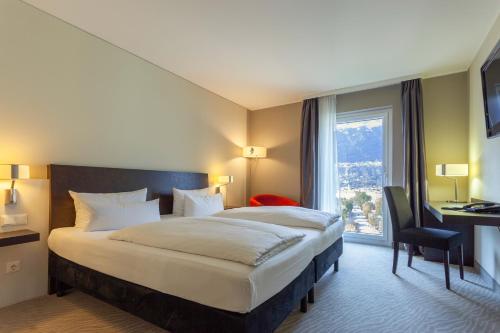 因斯布鲁克Tivoli Hotel Innsbruck的一间设有大床和窗户的酒店客房