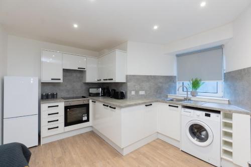 阿伯丁Central City Stay - 1 Bed Apartment in Aberdeen的厨房配有白色橱柜和洗碗机。