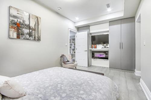 多伦多Charming and Luxurious 2BR+1Bath Guest Suite的一间白色卧室,配有床和电视