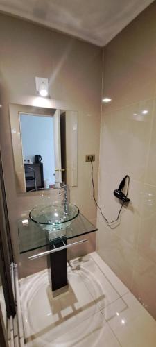 洛斯安第斯Hotel Los Andes的一间带玻璃水槽和镜子的浴室