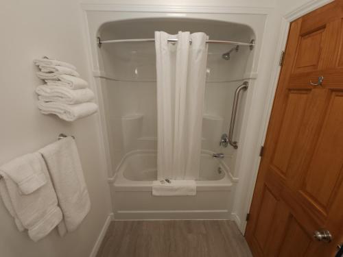 沃瓦Outdoorsman Motel的带淋浴和白色毛巾的浴室