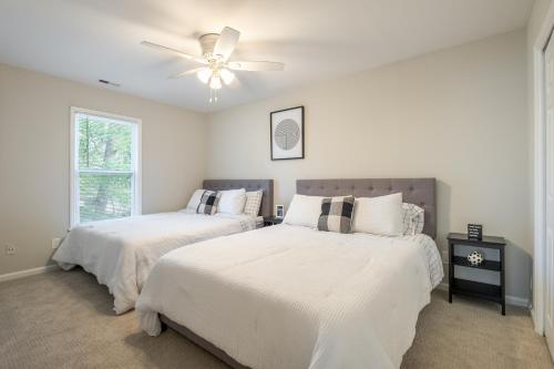 夏洛特Modern Stunning SouthPark/Cotswold Home!的一间卧室配有两张床和吊扇