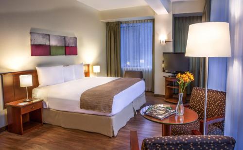 利马Del Prado Hotel的酒店客房设有一张大床和一张桌子。