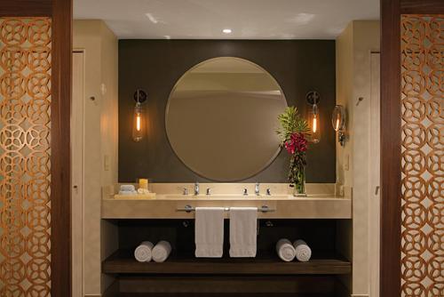 CulebraSecrets Papagayo All Inclusive - Adults Only的浴室配有带镜子的盥洗盆和毛巾