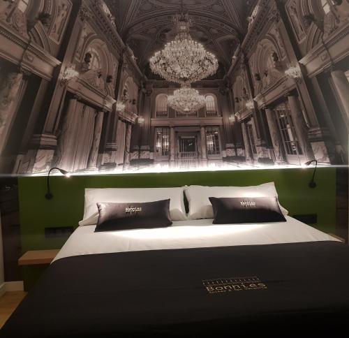 瓦伦西亚BONNIES Suites & Spa Valencia的一间卧室配有一张带吊灯的大床