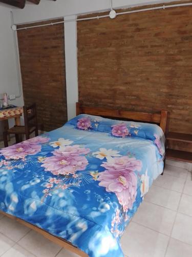 康考迪亚Lau departamentos的一张带鲜花的蓝色棉被的床