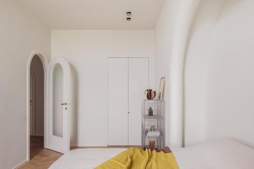 泽布吕赫DUNE DU PALACE的一间拥有白色墙壁的卧室和一张黄色毯子床