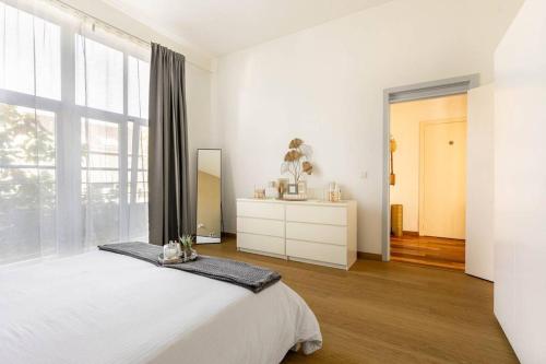 布鲁塞尔Luxueux appart proche de gare du Midi, à côté du Centre Ville的白色的卧室设有床和大窗户