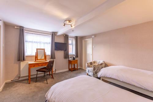 Hooton伍德科特酒店的酒店客房配有书桌和床。