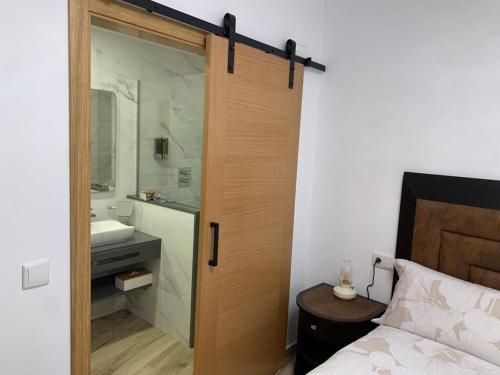 马尔帕尔蒂达德卡塞雷斯Casa rural Maila的浴室设有通往卧室的大门,卧室设有水槽