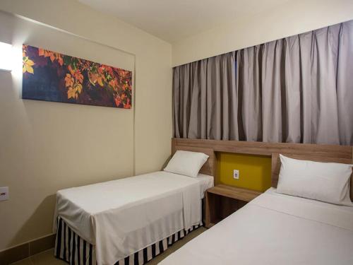 奥林匹亚Apartamento no Solar das Águas Park Resort的酒店客房设有两张床和窗户。