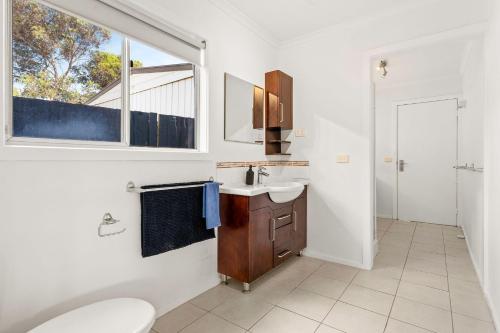 VentnorSea to Sunset View的一间带水槽和卫生间的浴室以及窗户。