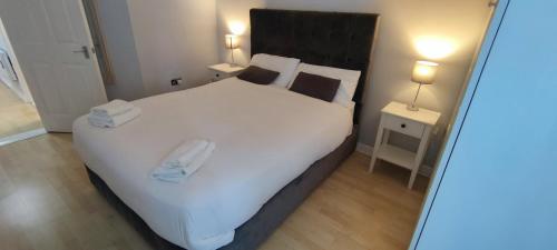 韦克斯福德Apartment in the heart of wexford town的卧室配有一张白色大床和两条毛巾