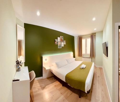 马德里阿巴迪亚马德里旅馆的一间卧室设有一张大床和绿色的墙壁