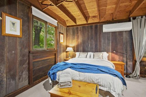 BilpinNungaroo Cottage的一间卧室设有一张床和木墙