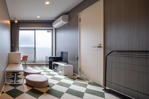 金泽Granrina Kanazawa - Female only apartment hotel的客房设有带一张床和电视的卧室。