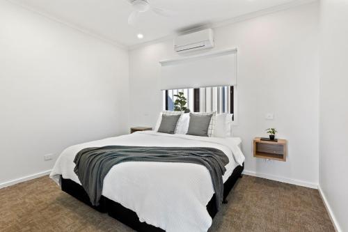 林肯港Port Lincoln Beachfront Apartments的白色的卧室设有一张大床和一个窗户