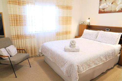 布罗肯希尔卡朋度假屋的卧室配有床、椅子和窗户。