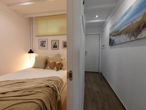 拉皮内达Just Oliver Holidays - Paradis Playa Seafront的卧室配有一张床,墙上挂有绘画作品