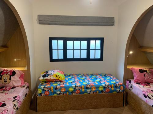 考普瓦利Disney cottage的一间卧室设有两张单人床和一个窗户。