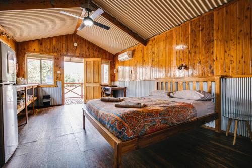 NynganNyngan Riverside Tourist Park的卧室配有一张床铺,位于带木墙的房间内