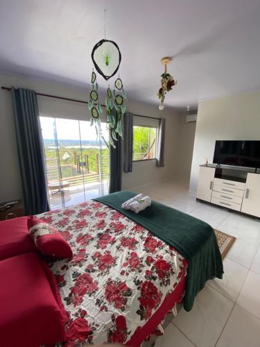巴西利亚Sunshine Chalé Brasília-DF的一间卧室设有一张床、一台电视和一张床。