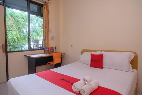 美娜多RedDoorz @ Jalan Pramuka Manado的一间卧室配有一张床,上面有两条毛巾