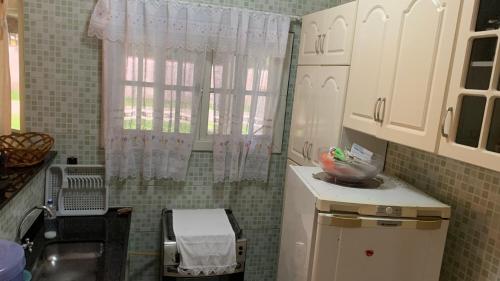 伊利亚孔普里达Casa pedrinhas的一个带水槽和窗户的小厨房