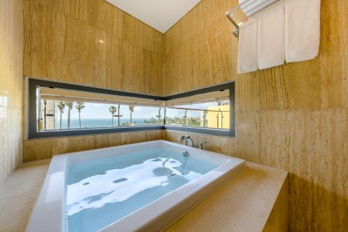 济州市STANFORD Hotel & Resort Jeju的窗户客房内的大浴缸
