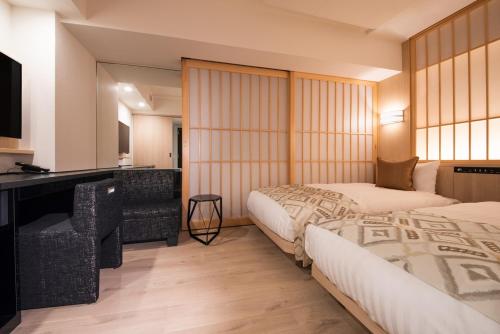 东京Hotel Vista Tokyo Tsukiji的酒店客房配有两张床和一张书桌