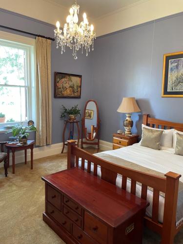 GretaLeconfield House的一间卧室配有一张大床和一个吊灯。
