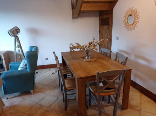 UdiasCasa con encanto en La Hayuela, situada a 5 min de Comillas的一间带木桌和椅子的用餐室