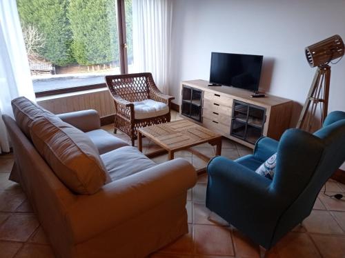 UdiasCasa con encanto en La Hayuela, situada a 5 min de Comillas的客厅配有沙发、椅子和电视